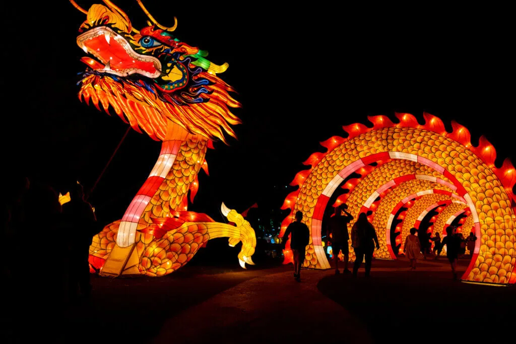 An illuminated dragon and glowing arched lantern tunnel at Dragon Lights Reno