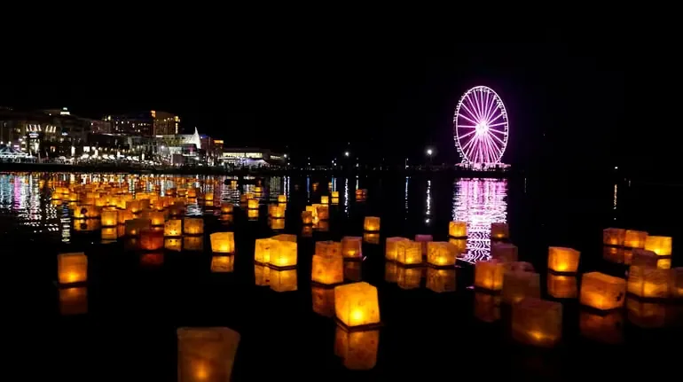 Floating lanterns on the Potomac with the Capital Wheel illuminated at National Harbor