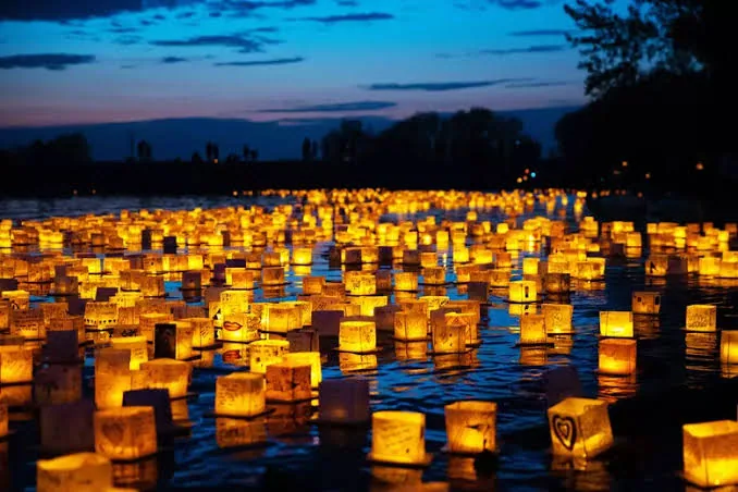 Hundreds of glowing paper lanterns floating on the water at the Staten Island Water Lantern Festival
