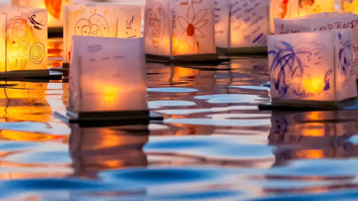 Example photography of decorated paper lanterns floating on water at dusk; not this event. Location and season unspecified by the source.